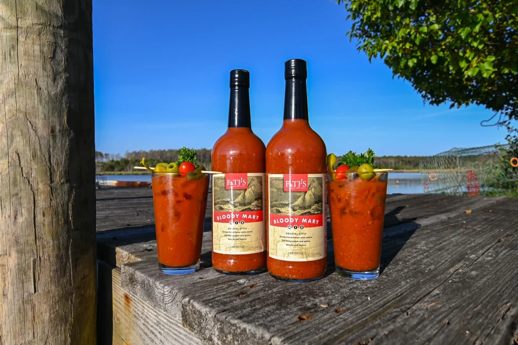 Two Bloody Mary drinks and F&TJ’s bottle arranged on a dock in coastal North Carolina